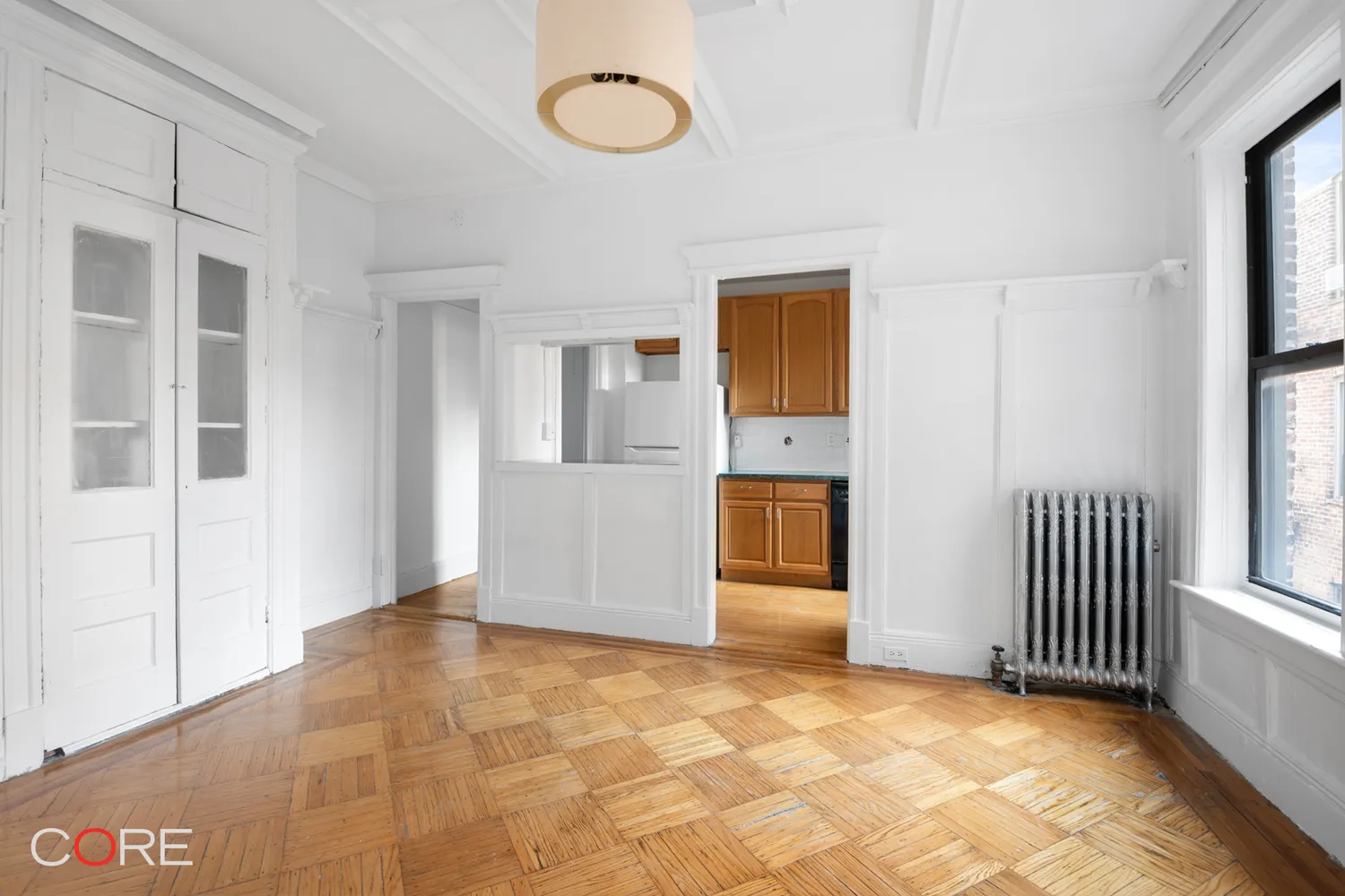 living room with passthrough into the kitchen and a closet with glass panes