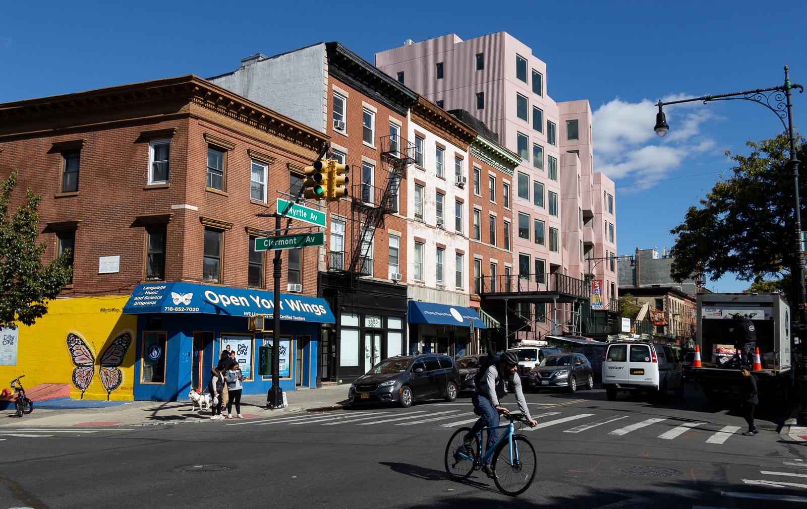 a new pink building next to brick buildings on myrtle avenue