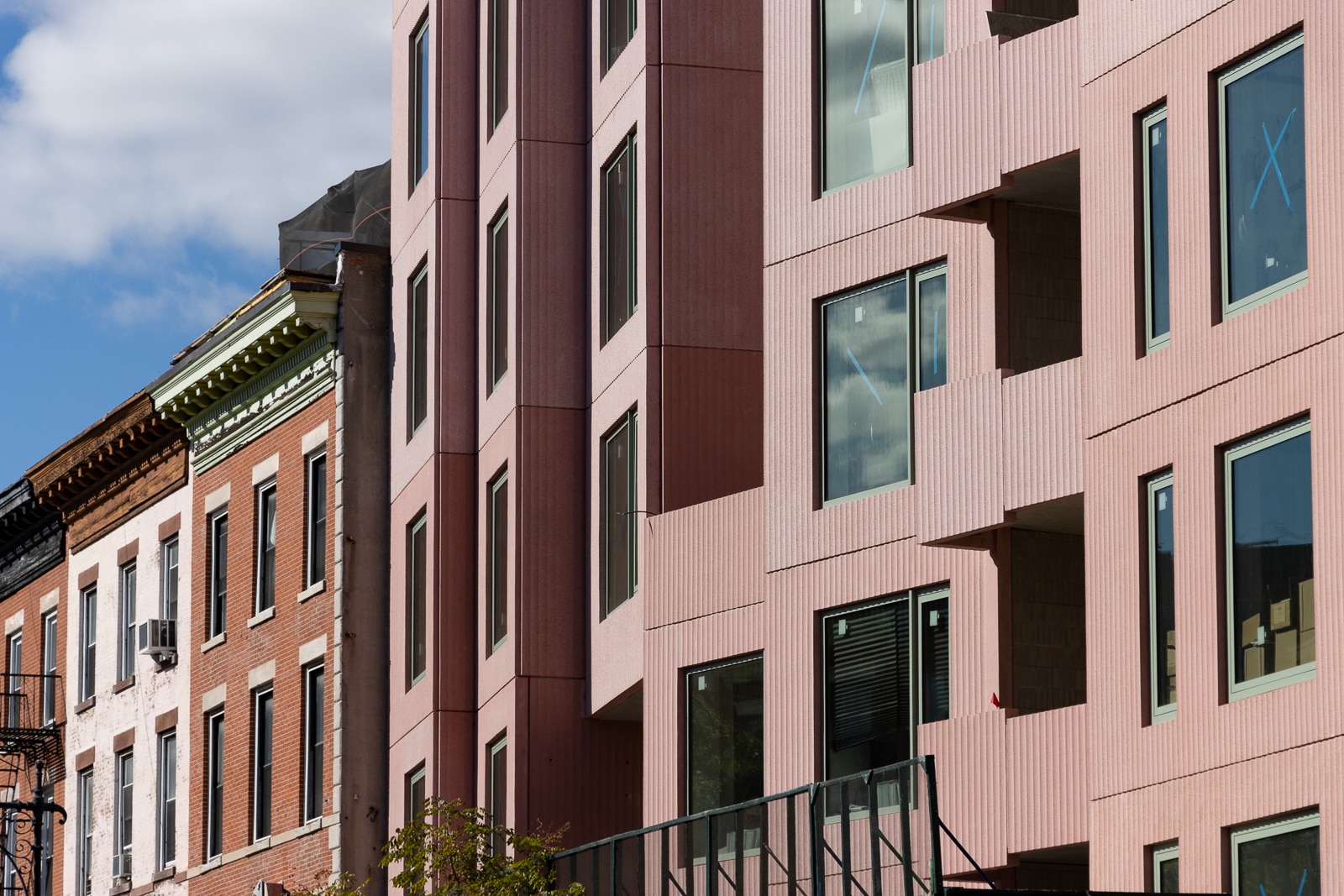 new pink building and older brick buildings on myrtle avenue