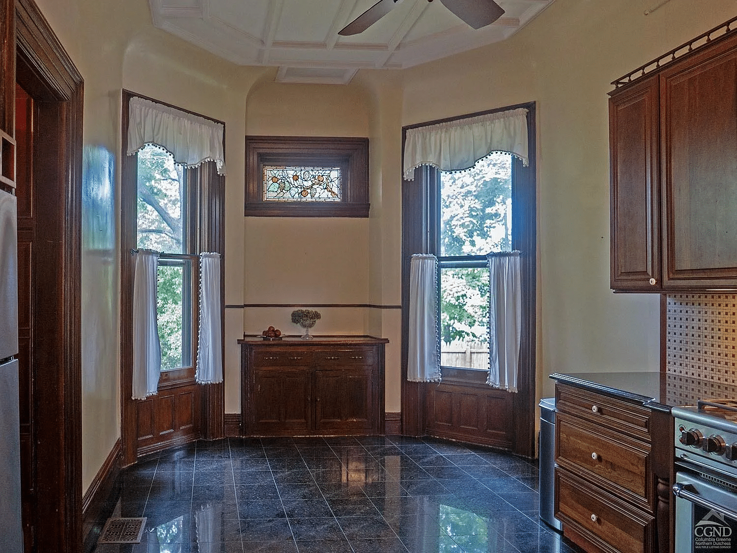 kitchen with black tile floor, wood cabinets and a stained glass window