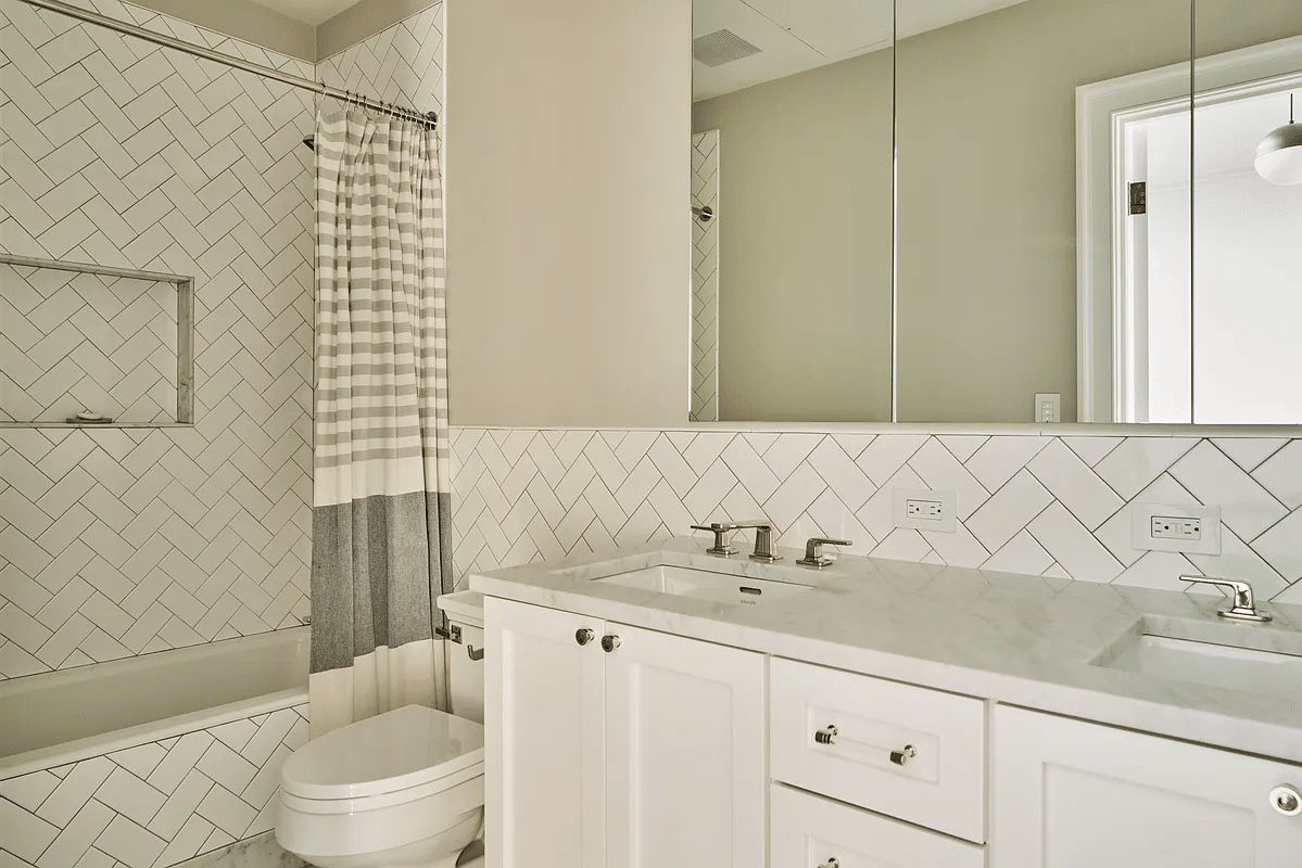 bathroom with white fixtures, dual vanity