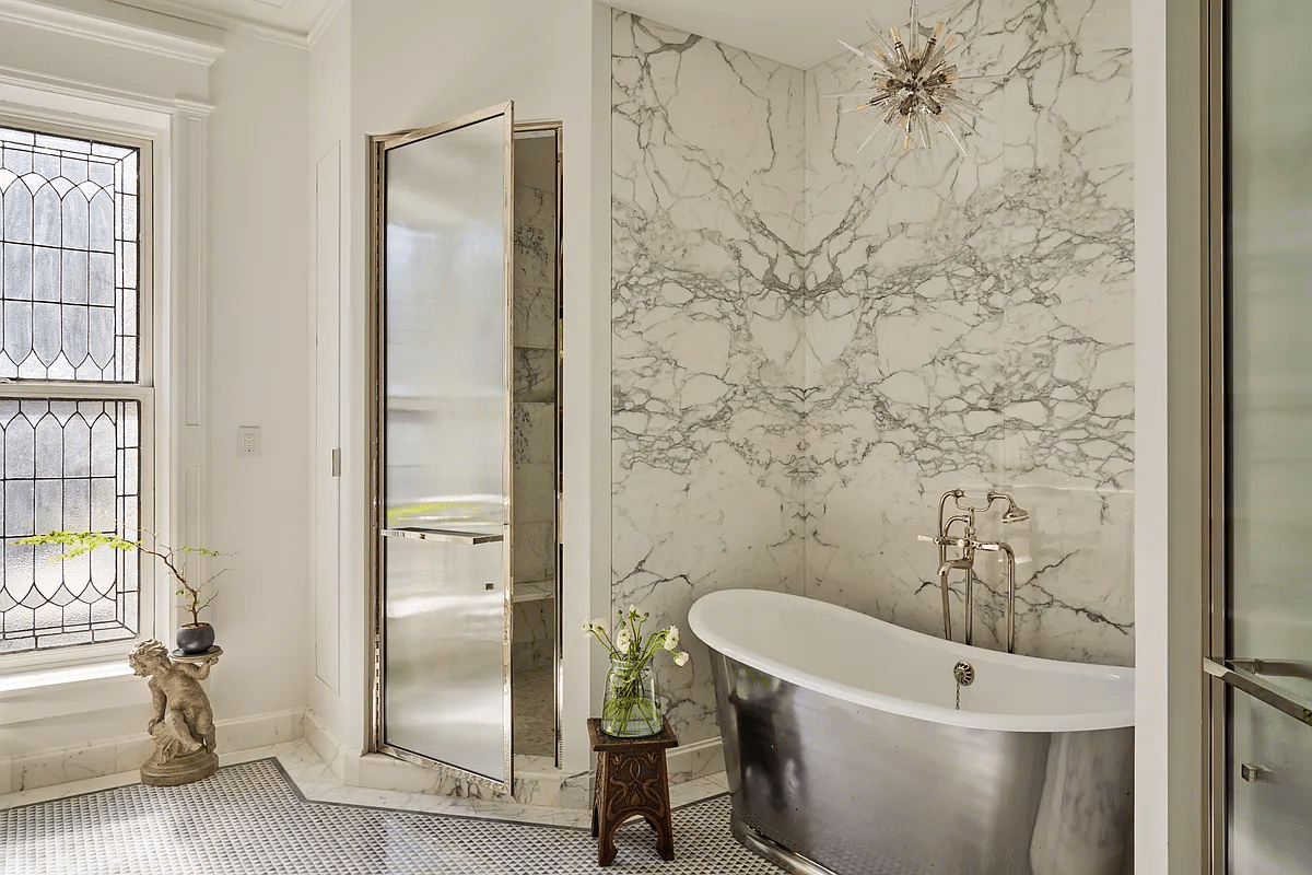 bathroom with silver tub, glass door to shower