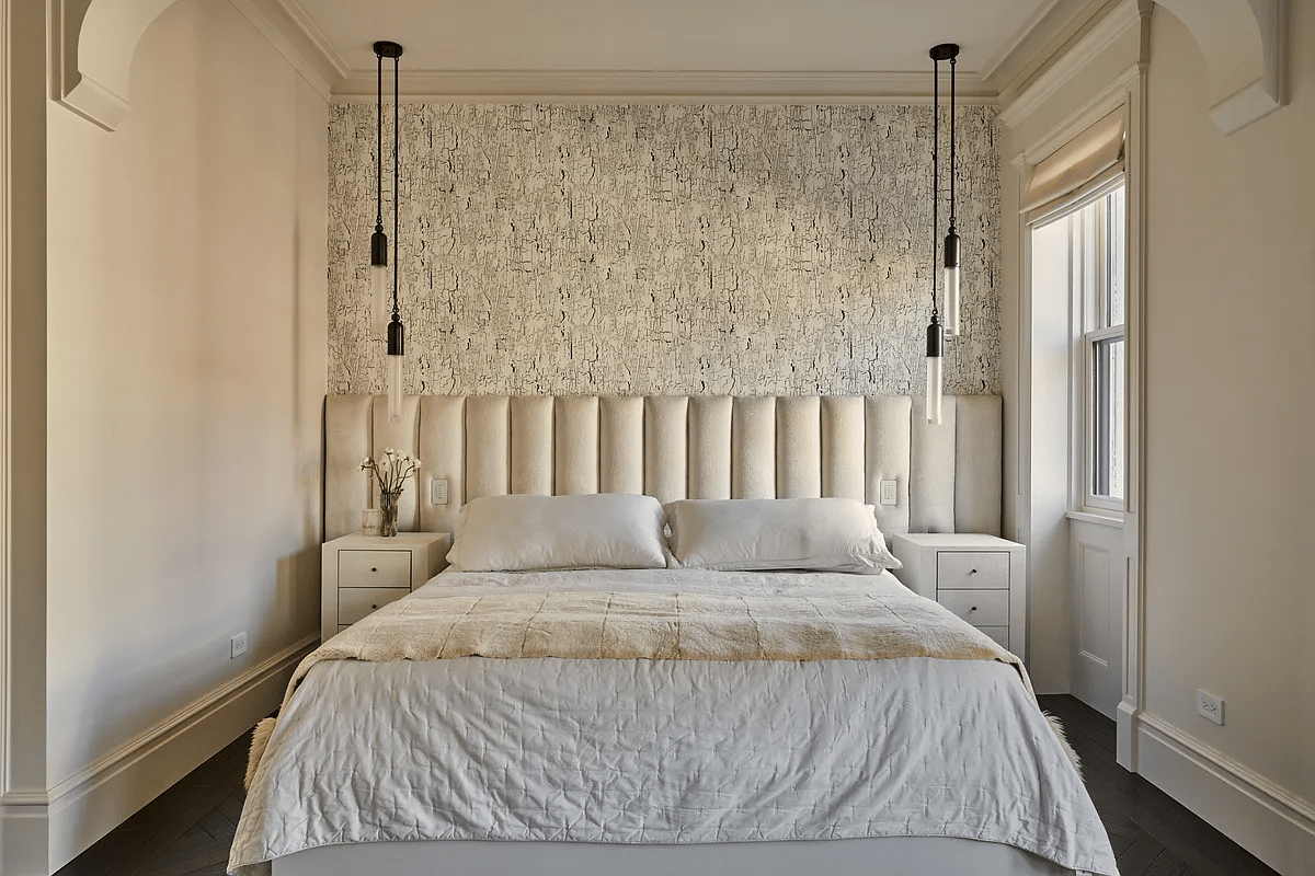 bedroom with cream walls, a wall of wallpaper