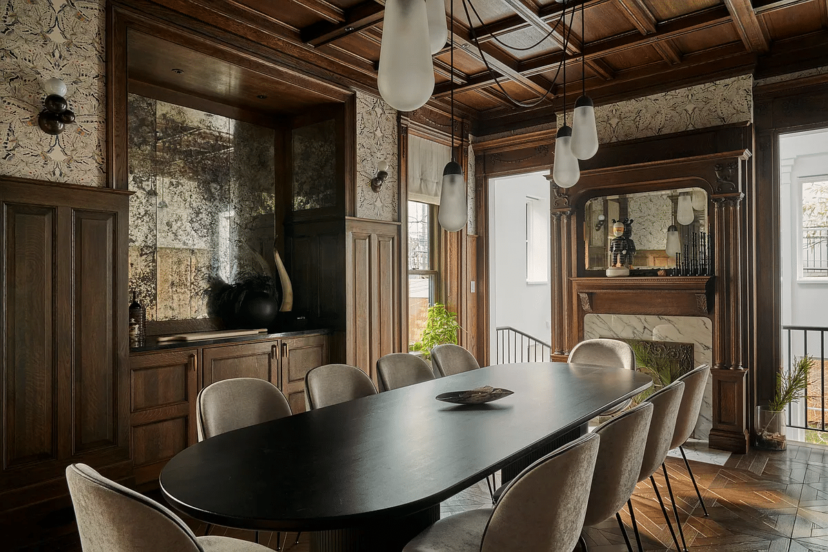 dining room with wainscoting, modern built-in cabinets in niche, and a mantel