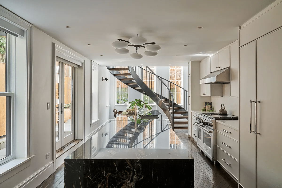 modern kitchen with white cabinets and a view to the new, curved stair