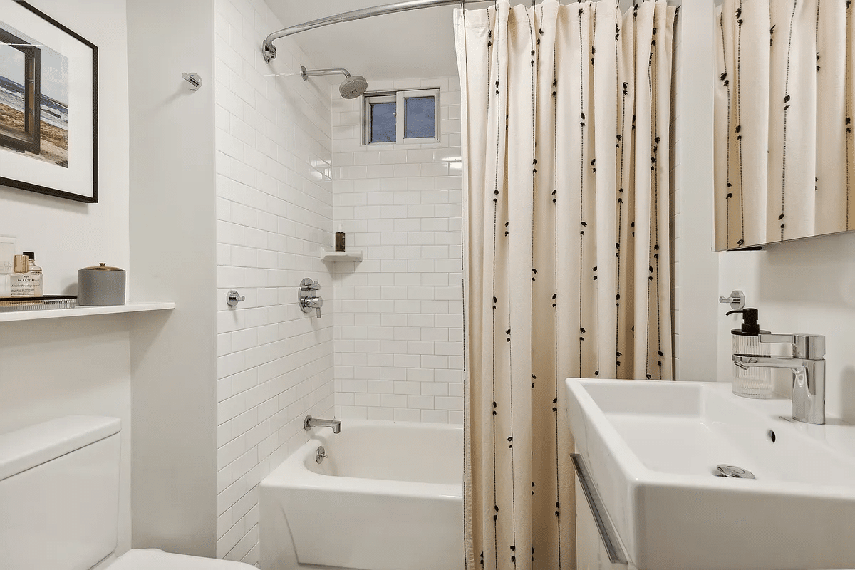 bathroom with white fixtures, tub