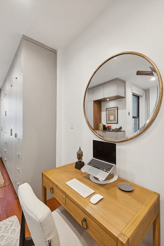 desk in the bedroom with view of gray painted built-in storage adjacent