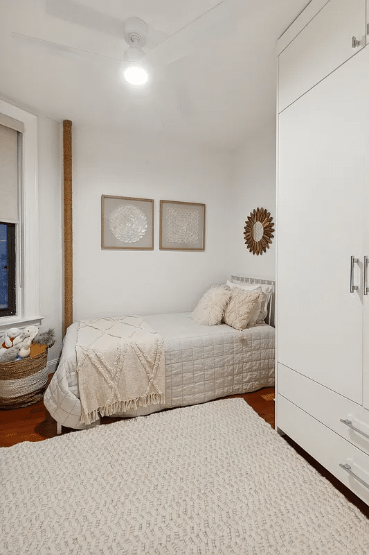 bedroom with white walls, wood floor, and large white closet