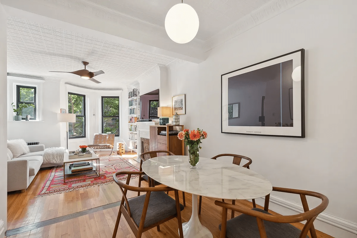 open plan dining and living areas with white walls and wood floor