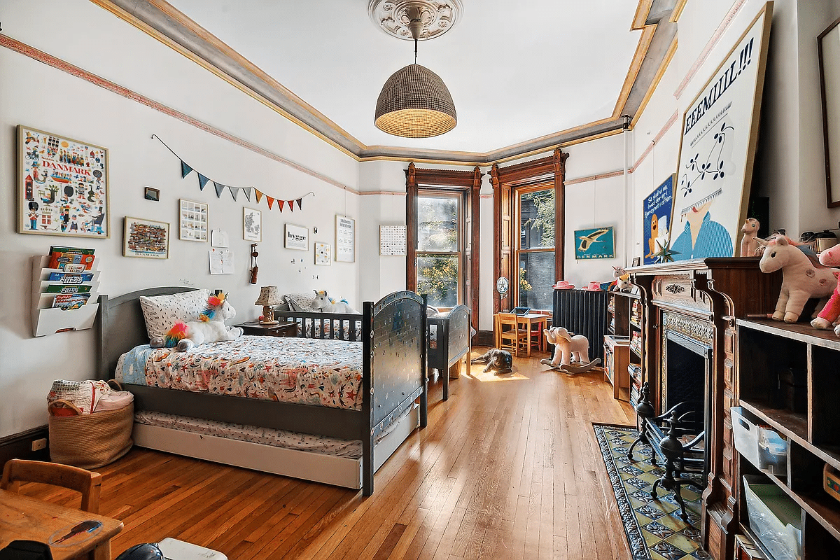 bedroom with wood floor, wood mantel, picture rails, ceiling medallion