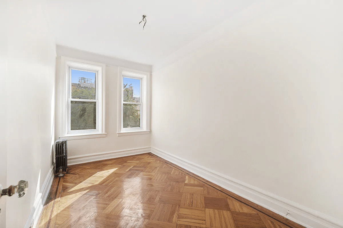 narrow bedroom with two windows