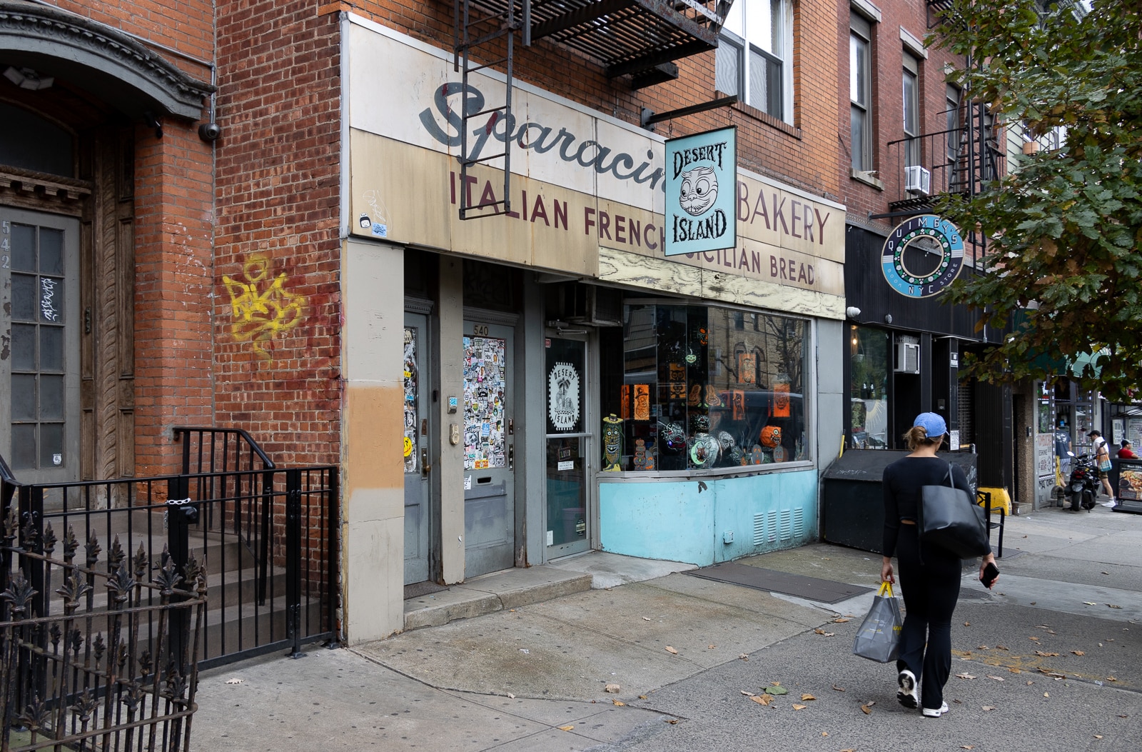 williamsburg- storefront of desert island comics with a blue sign and the old bakery sign