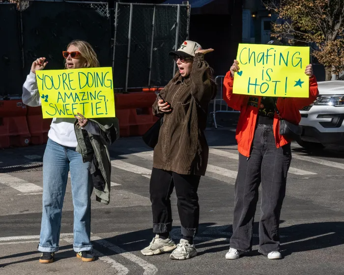 viewers holding signs and cheering