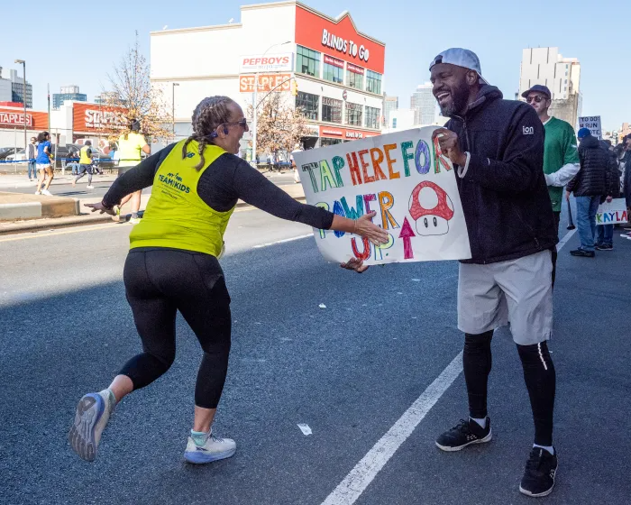 runner tapping a sign