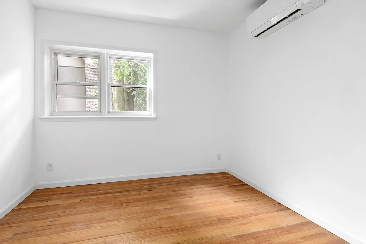 bedroom with wood floor, mini split on the wall