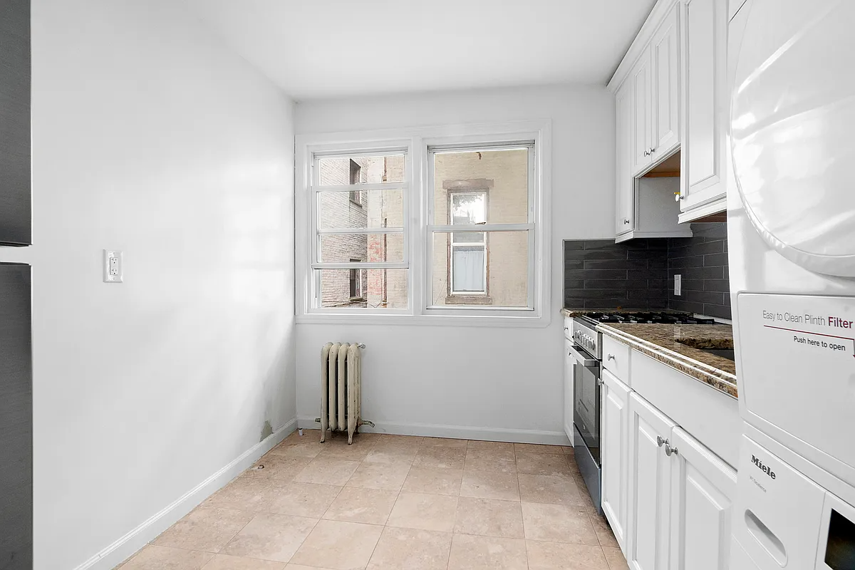 windowed kitchen with a stacked washer and dryer