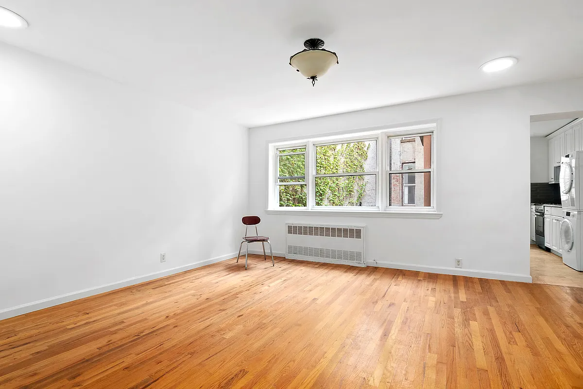 clinton hill - living room with wood floor and view into kitchen