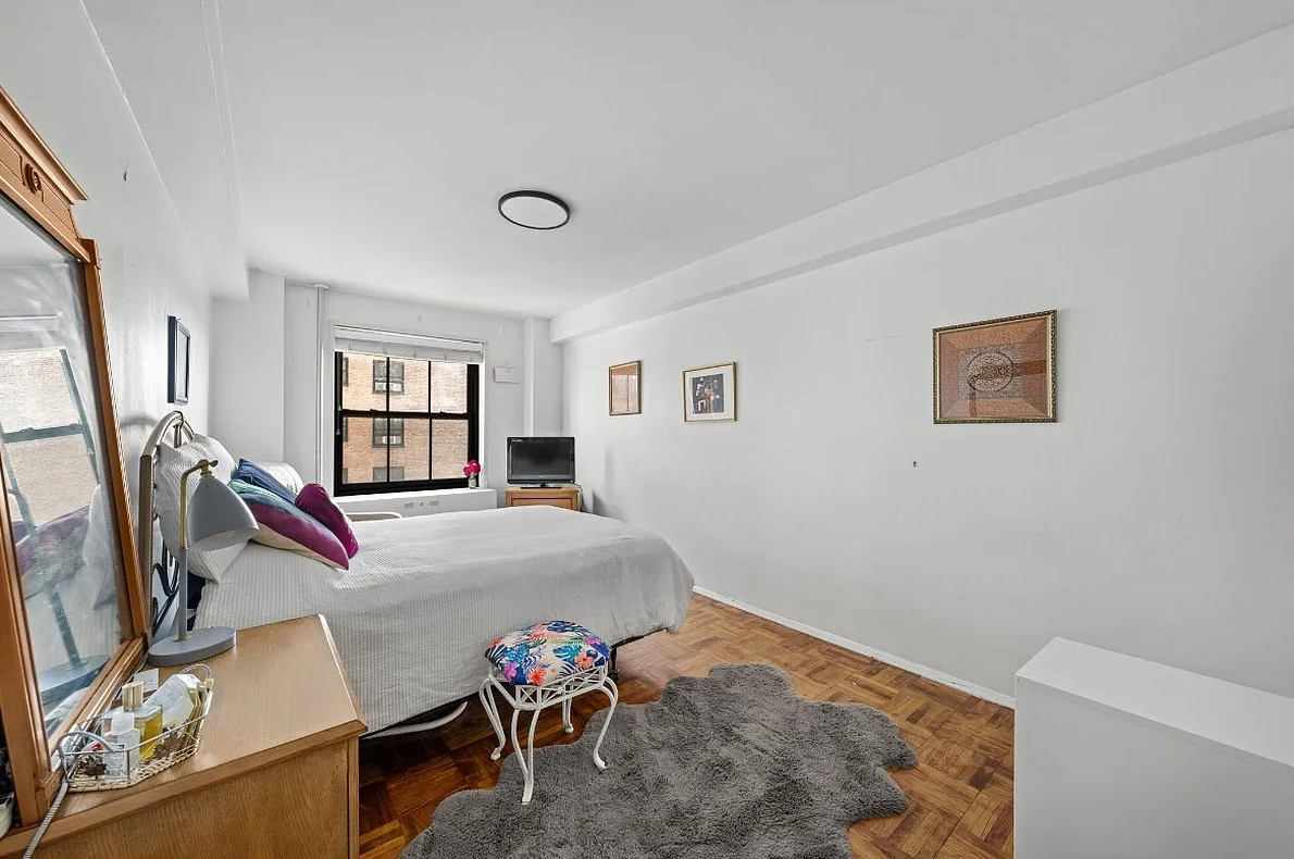 bedroom with parquet floor, white walls, one window