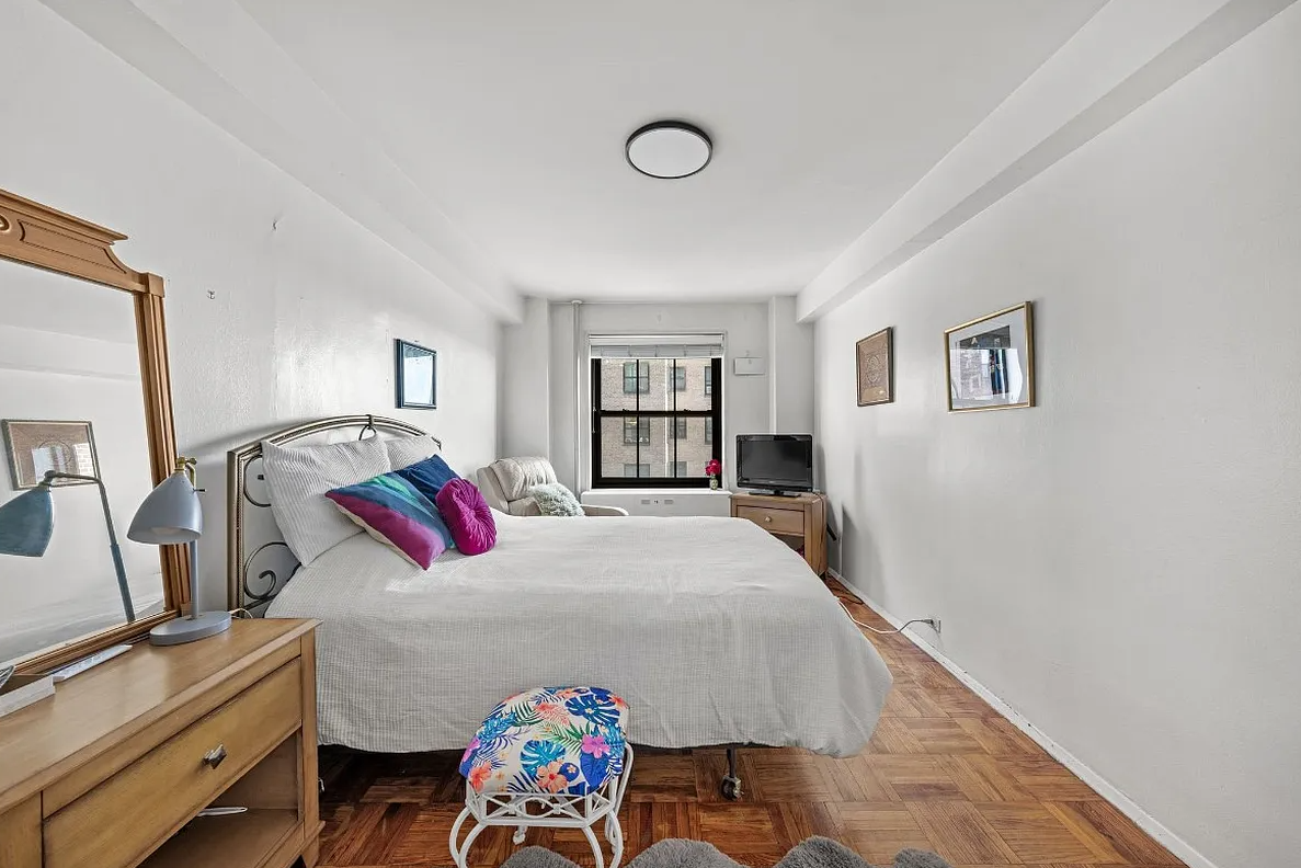 bedroom with parquet floor, white walls, one window