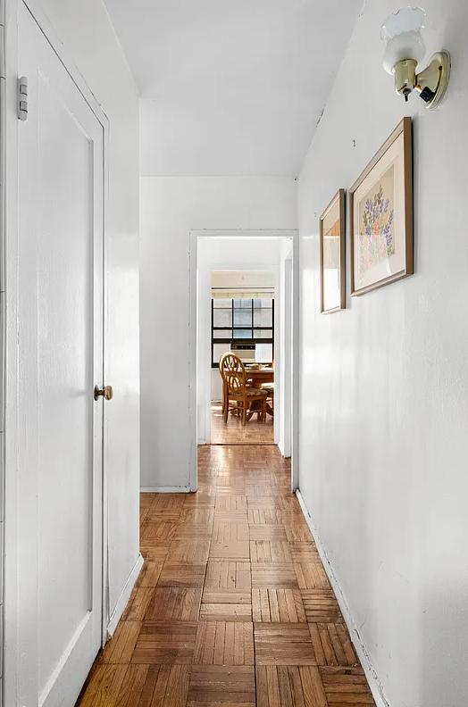 hallway with parquet floor, white walls