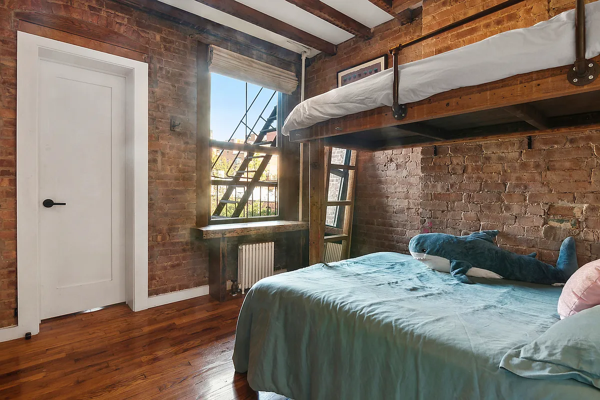 bedroom with exposed brick walls and bunk beds