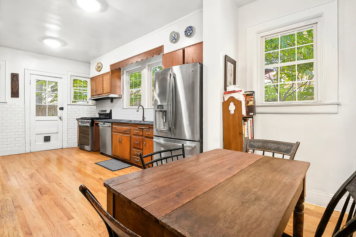 kitchen with wood floor, wood cabinets, white subway tile