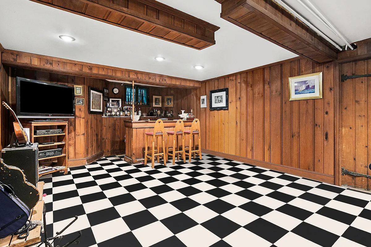 the basement rumpus room with knotty pine walls and a black and white checkerboard floor