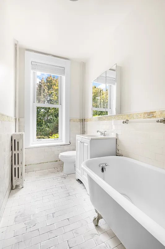 bathroom with claw foot tub, period border tile, subway tile