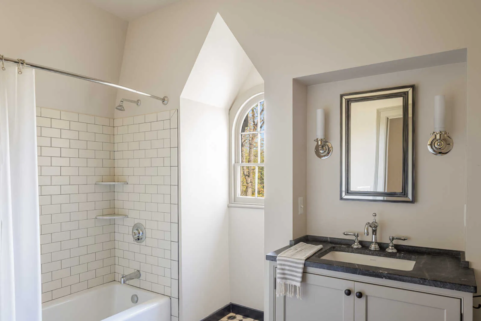 bathroom with white tub and subway tile