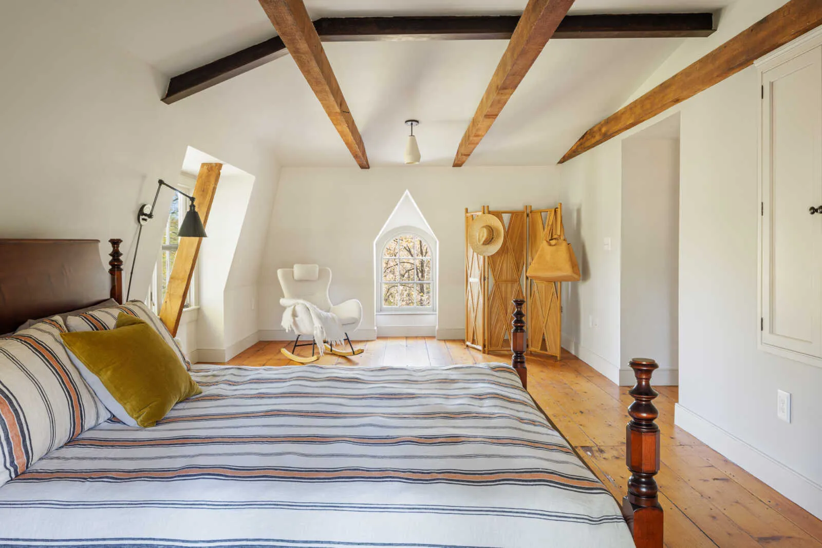 bedroom with wide planked floorboards and exposed beams