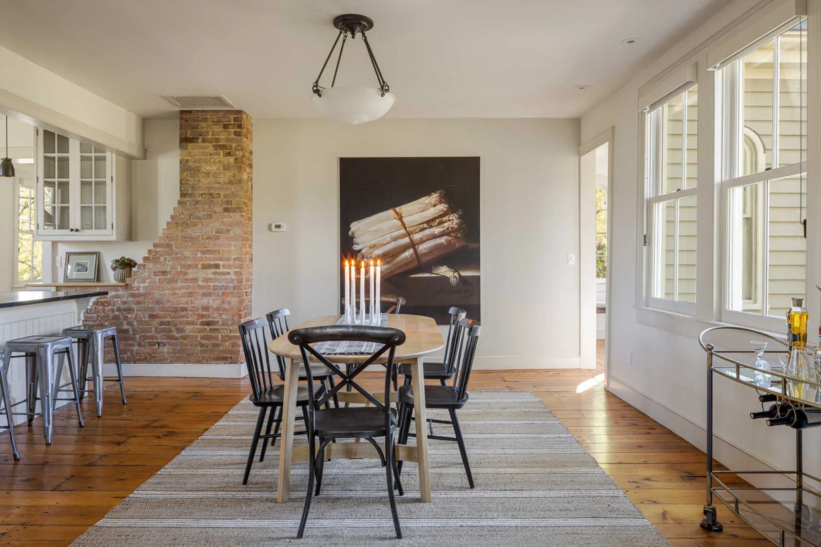 dining area with windows to outdoors and a view into kitchen