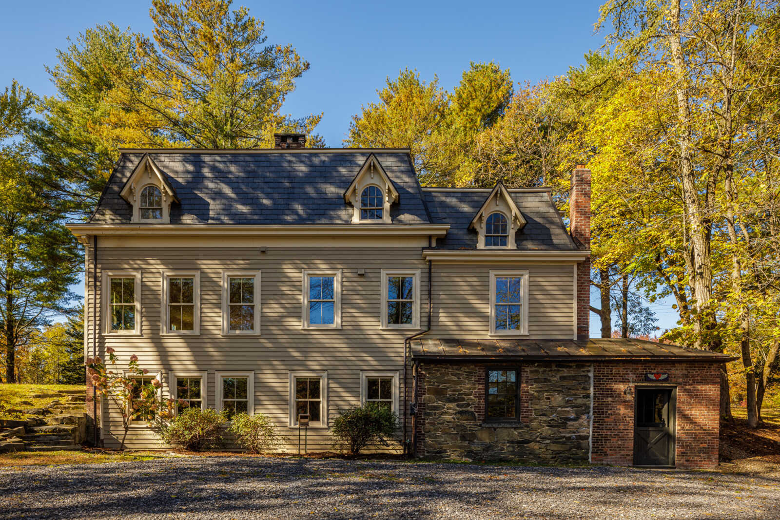 rear facade with a one story stone and brick wing