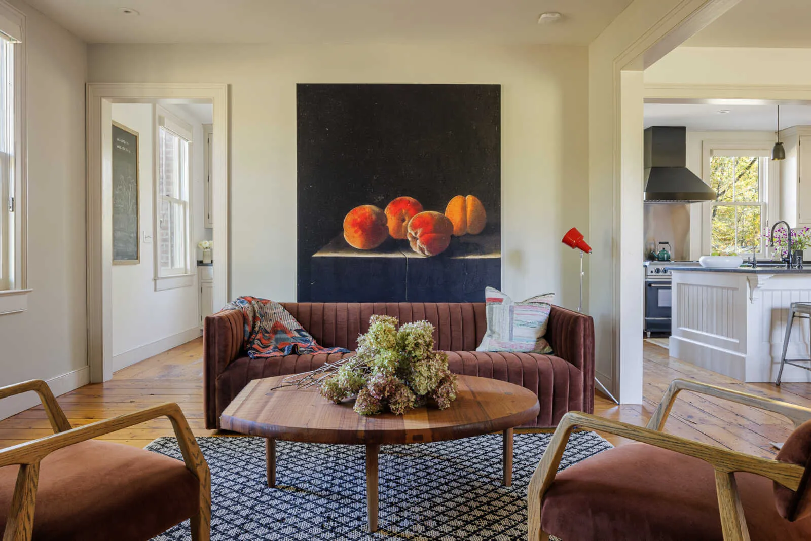 living area adjacent to kitchen with wide planked wood floors