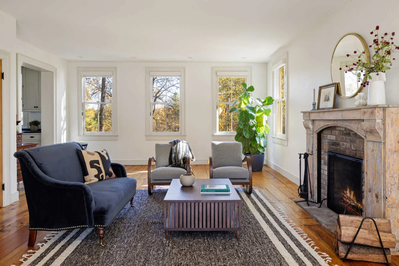 parlor with stone mantel, wide planked floorboards