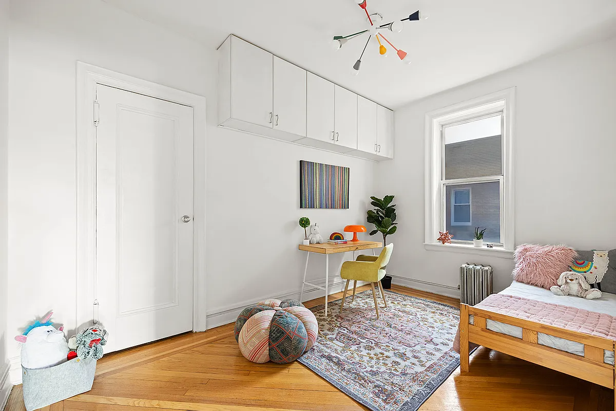 bedroom with parquet floor, white walls, upper storage