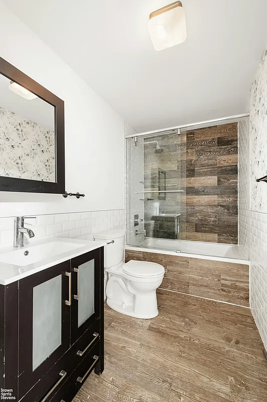 bathroom with faux wood tiles on floor and tub surround mixed with white subway tile