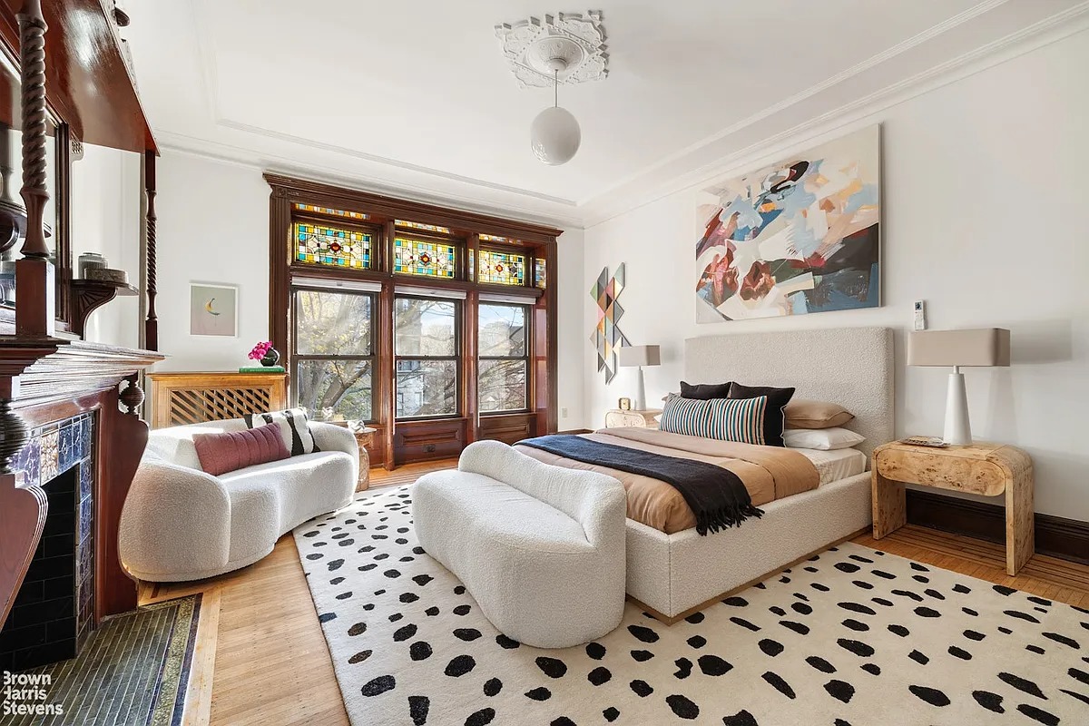 bedroom with wood floor, mantel, ceiling medallion