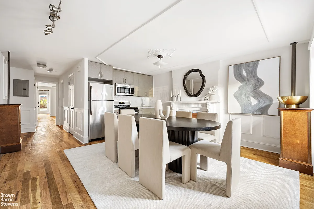 garden level dining area and small kitchen with white walls, wood floor