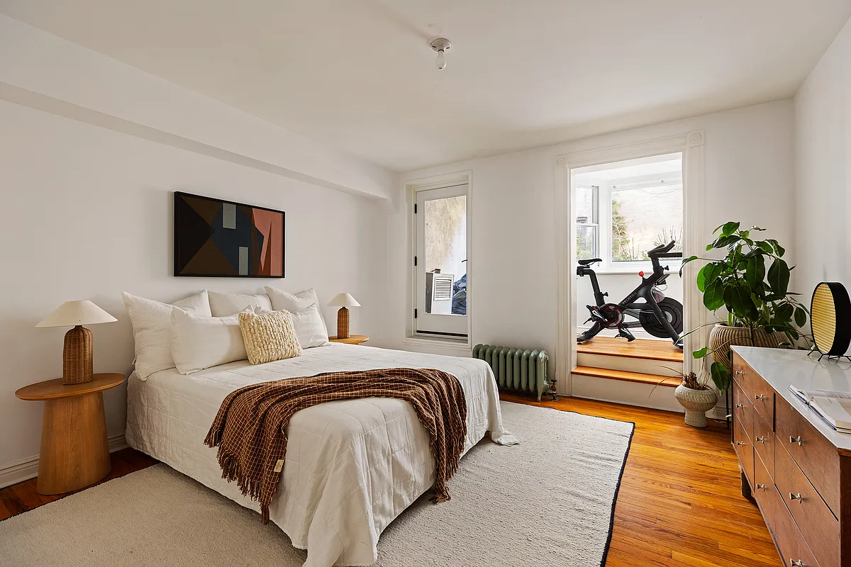 garden level bedroom with wood floor, steps up to sun room and garden