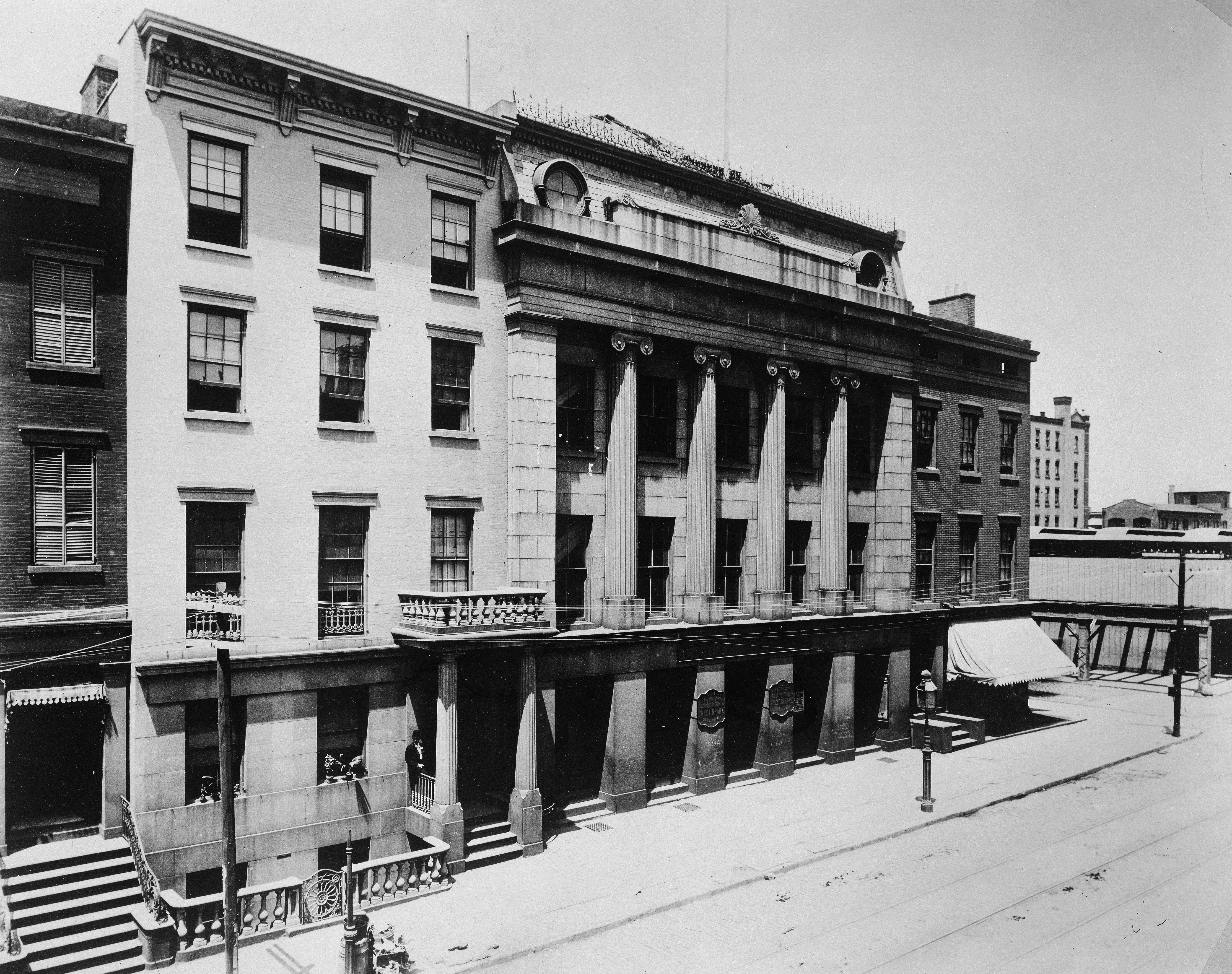 black and white photo of buildings including one with a colonnade 