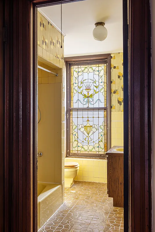 bathroom with stained glass window, yellow fixtures